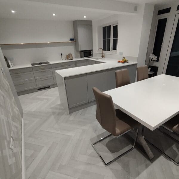 A dining area styled with Chatsworth Grey flooring, featuring a beautifully set table and a centerpiece of an intricately designed cake. The grey flooring complements the elegant and refined atmosphere.